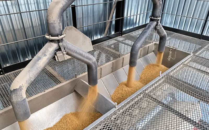 Fertilizer material feeding into industrial hoppers within a processing plant
